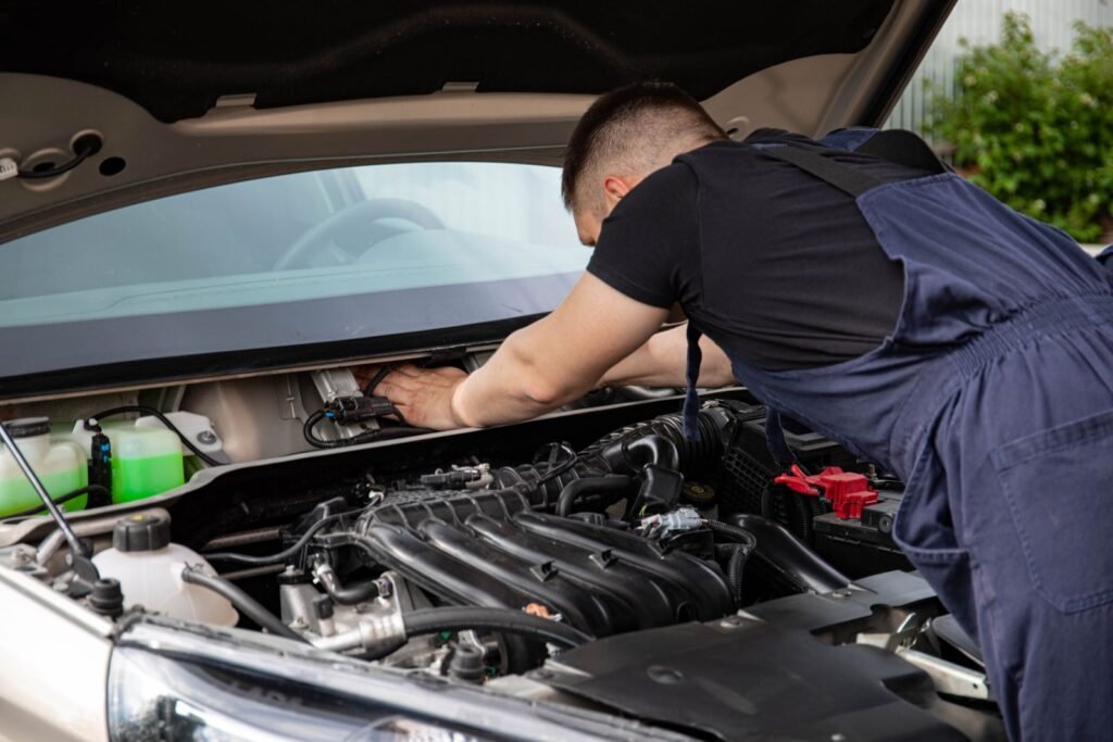 A mechanic working under the hood of a vehicle